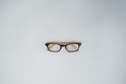 Stylish eyeglasses centered on a plain gray background, perfect for eyewear ads.